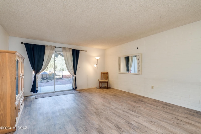 spare room featuring wood-type flooring and a textured ceiling