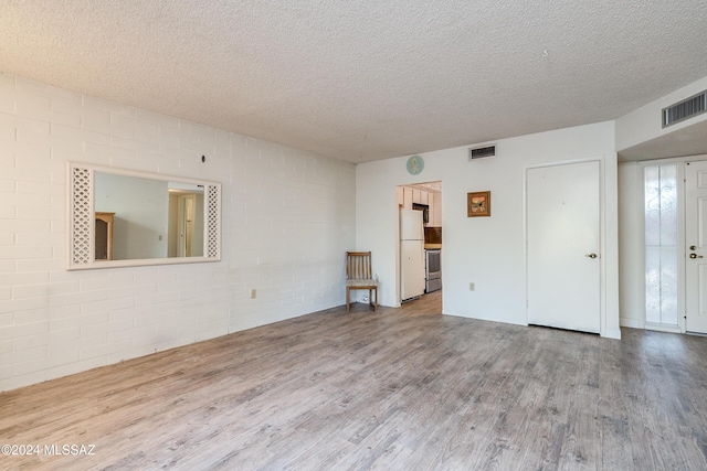 spare room featuring a textured ceiling and hardwood / wood-style flooring