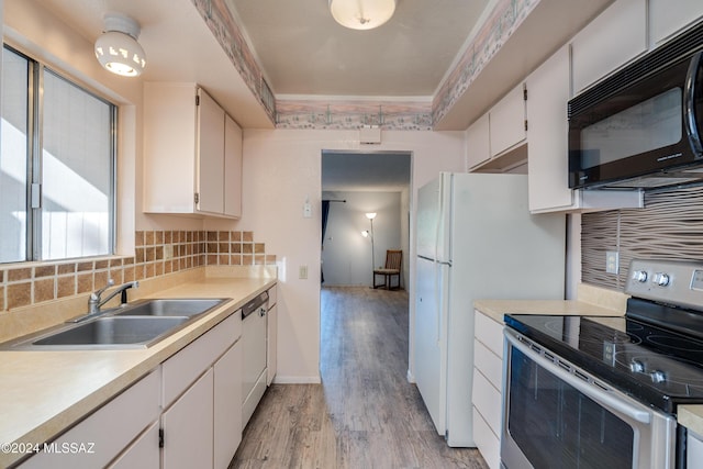 kitchen featuring sink, tasteful backsplash, light hardwood / wood-style floors, stainless steel range with electric stovetop, and white cabinets