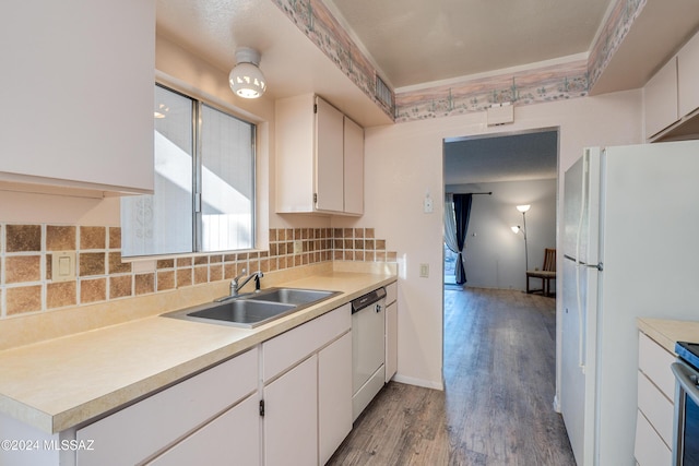 kitchen with white appliances, backsplash, sink, light hardwood / wood-style flooring, and white cabinetry