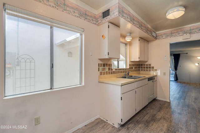 kitchen with dark wood-type flooring, white dishwasher, sink, decorative backsplash, and white cabinetry