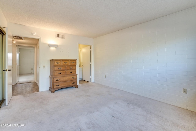 unfurnished bedroom with light colored carpet and a textured ceiling