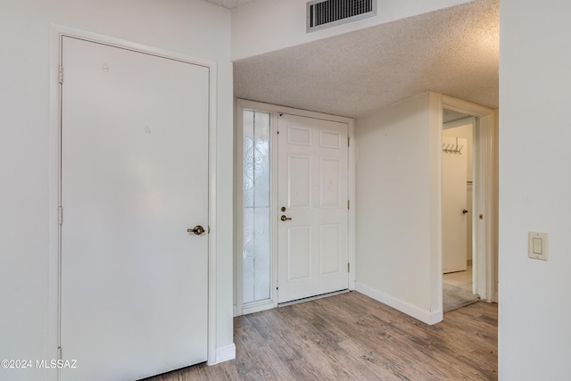 foyer featuring a textured ceiling and light hardwood / wood-style floors