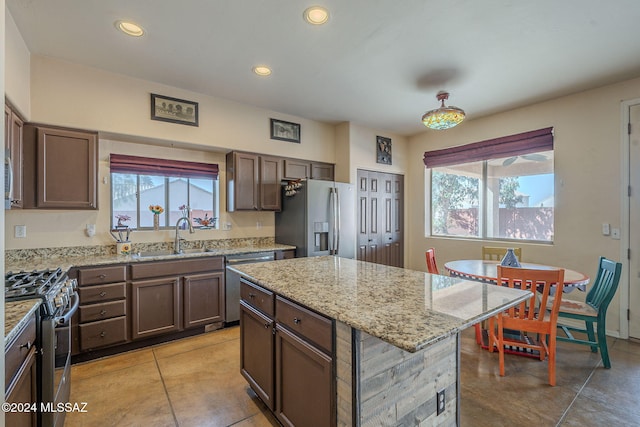 kitchen with plenty of natural light, a kitchen island, stainless steel appliances, and sink