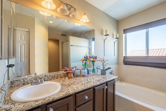 bathroom with vanity and a tub