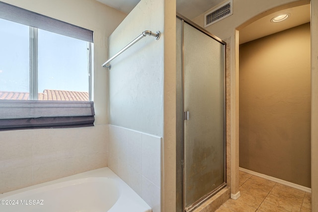 bathroom featuring tile patterned flooring and separate shower and tub