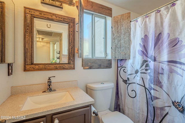 bathroom featuring a shower with curtain, vanity, and toilet