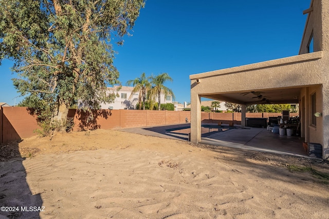 view of yard featuring ceiling fan and a patio