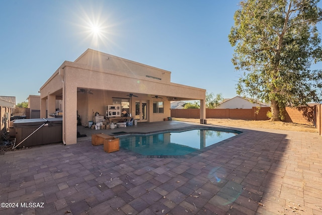 view of swimming pool featuring a patio area, ceiling fan, and a hot tub