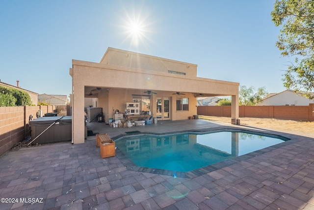 view of pool with ceiling fan, a patio, and a hot tub