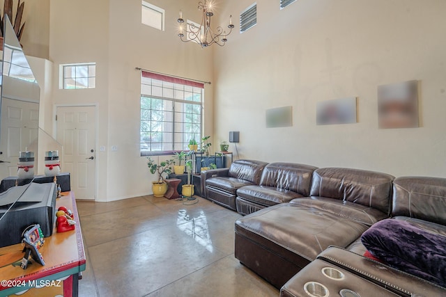 living room with a chandelier, concrete floors, and a high ceiling