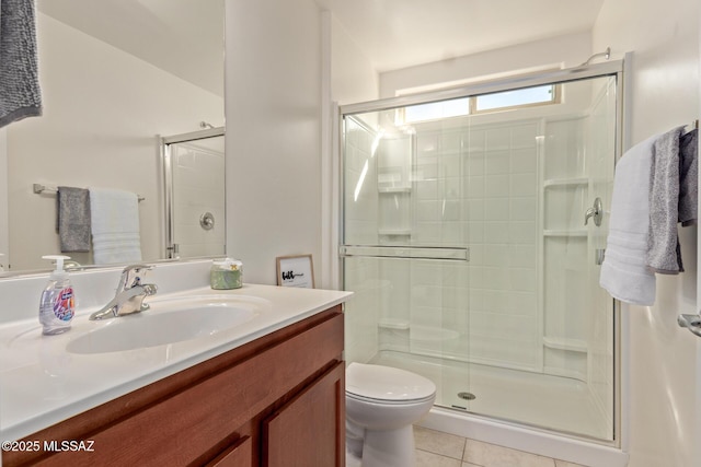 bathroom with tile patterned flooring, vanity, toilet, and a shower with door