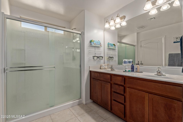 bathroom with tile patterned flooring, vanity, and walk in shower