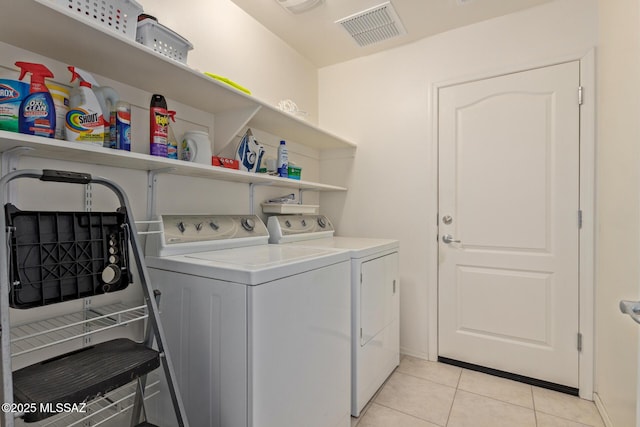 washroom with light tile patterned flooring and washing machine and dryer