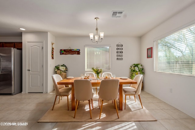 dining room with a notable chandelier and light tile patterned floors