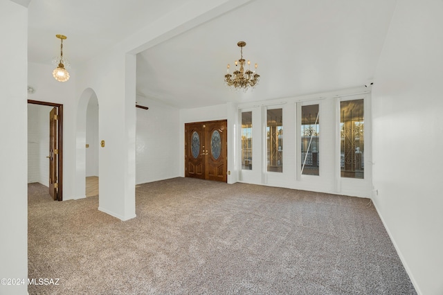 empty room with carpet and a notable chandelier