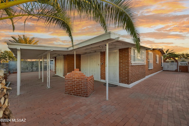 patio terrace at dusk featuring a carport