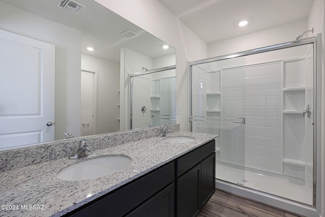 bathroom featuring hardwood / wood-style floors, vanity, and an enclosed shower