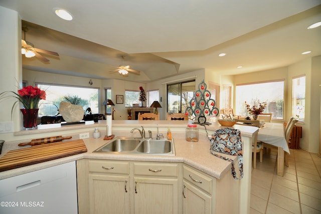 kitchen featuring dishwasher, sink, ceiling fan, light tile patterned flooring, and kitchen peninsula