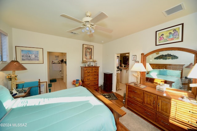 bedroom featuring hardwood / wood-style flooring, ceiling fan, and ensuite bath