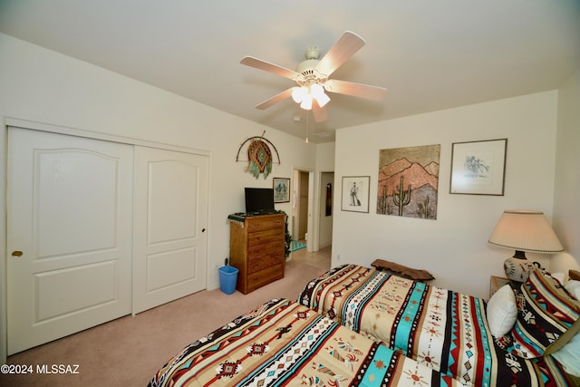 bedroom featuring ceiling fan, a closet, and light colored carpet