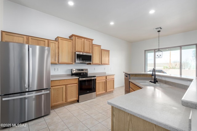 kitchen with appliances with stainless steel finishes, light brown cabinetry, sink, hanging light fixtures, and light tile patterned floors