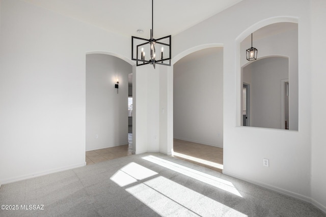 unfurnished dining area with light colored carpet and an inviting chandelier