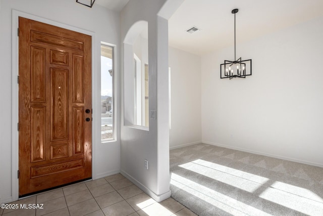 tiled foyer entrance featuring a notable chandelier