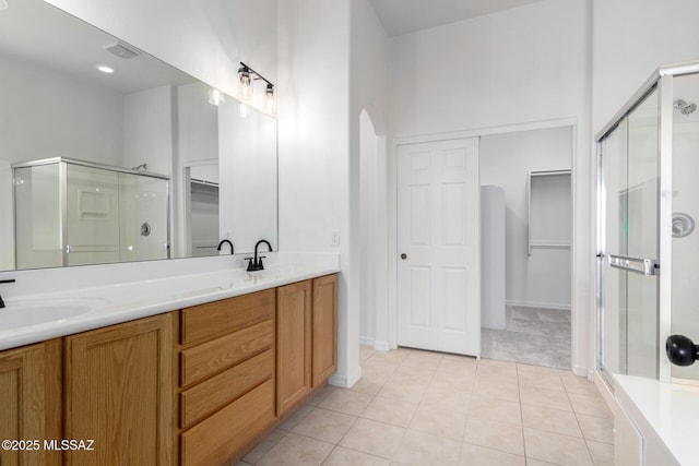 bathroom featuring vanity, tile patterned floors, and a shower with shower door