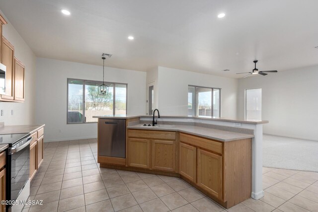 kitchen featuring light brown cabinets, an island with sink, hanging light fixtures, and appliances with stainless steel finishes