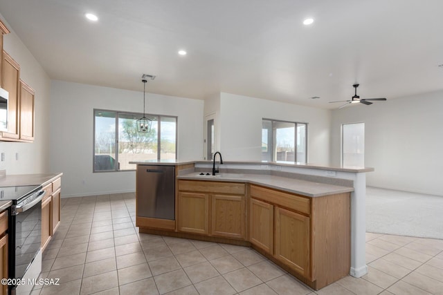 kitchen featuring sink, a kitchen island with sink, stainless steel appliances, light tile patterned flooring, and decorative light fixtures