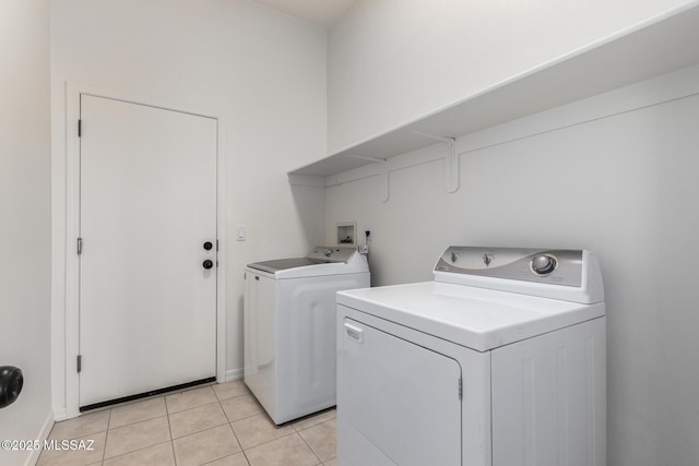 laundry area with washer and dryer and light tile patterned floors