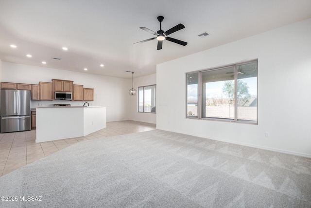 unfurnished living room with light colored carpet and ceiling fan