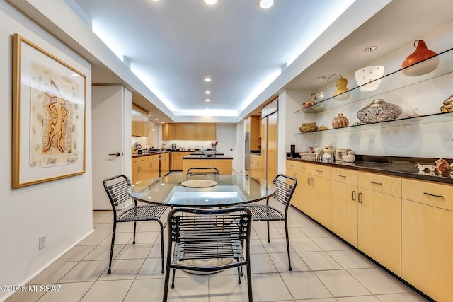 tiled dining area with a tray ceiling