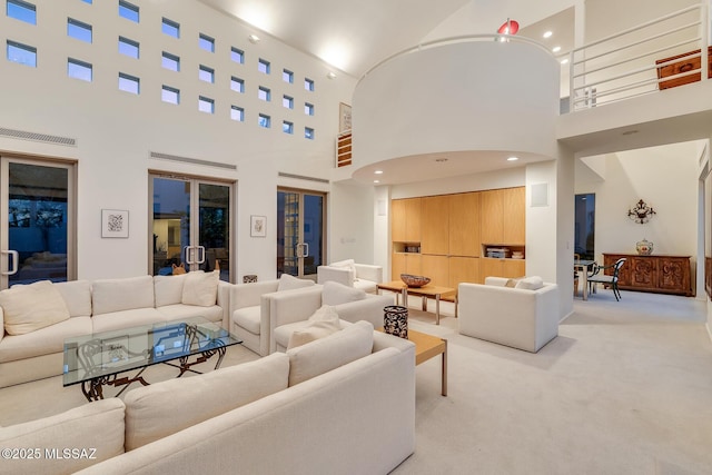 living room featuring light colored carpet and a high ceiling