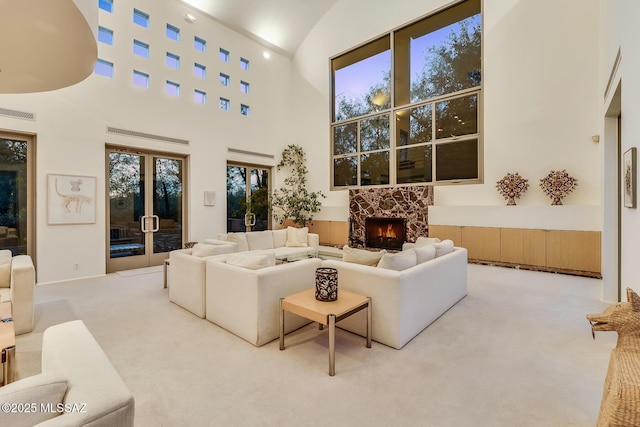 living room featuring high vaulted ceiling and light carpet