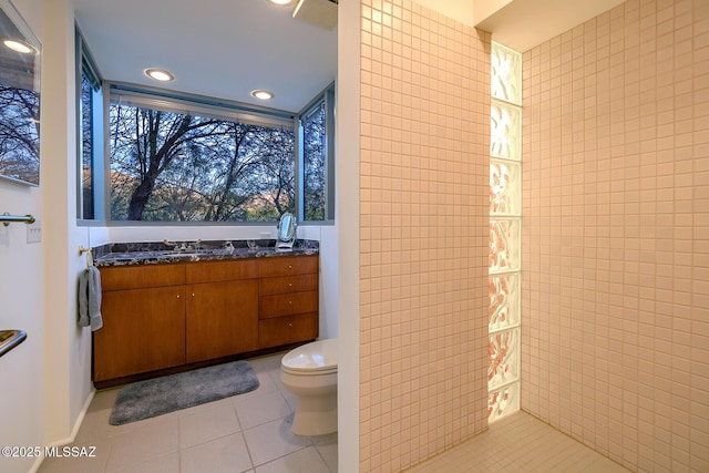 bathroom with tile patterned flooring, vanity, tile walls, and toilet