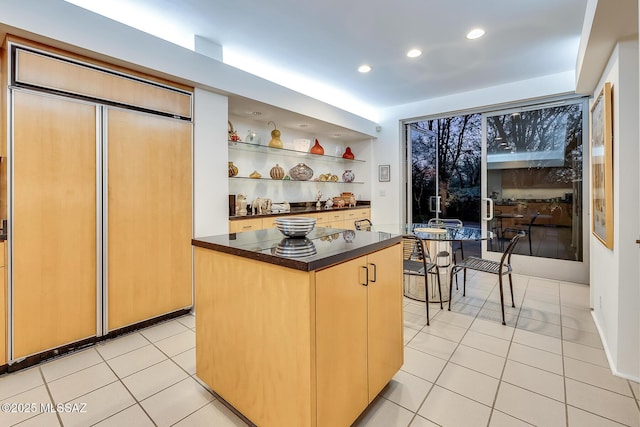 kitchen featuring paneled built in refrigerator, light tile patterned floors, and a kitchen island