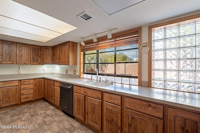 kitchen featuring a textured ceiling, dishwasher, sink, and track lighting