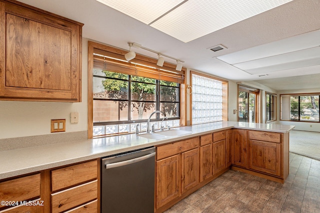 kitchen with kitchen peninsula, stainless steel dishwasher, plenty of natural light, and sink