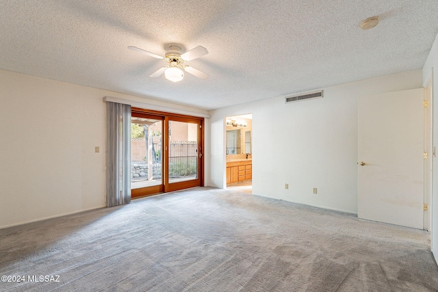 carpeted empty room with ceiling fan and a textured ceiling