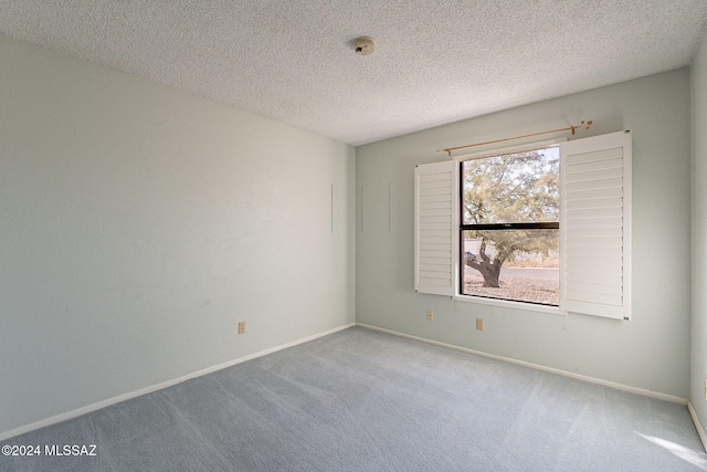 carpeted spare room with a textured ceiling