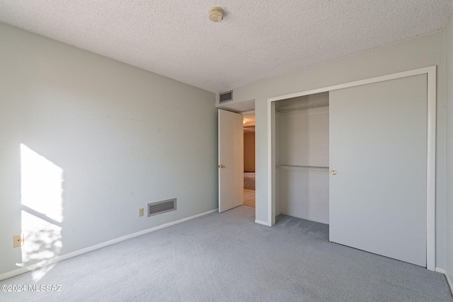 unfurnished bedroom featuring a closet, carpet floors, and a textured ceiling