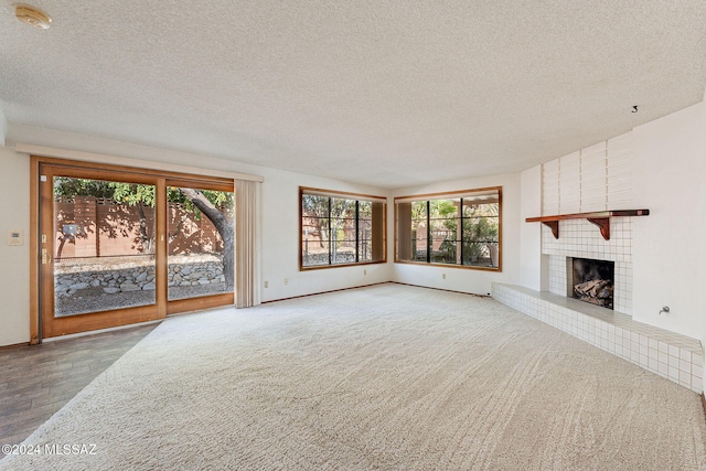 unfurnished living room featuring hardwood / wood-style flooring, a fireplace, and a textured ceiling