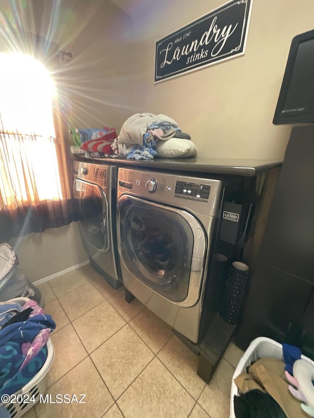 laundry room with washing machine and dryer and light tile patterned floors