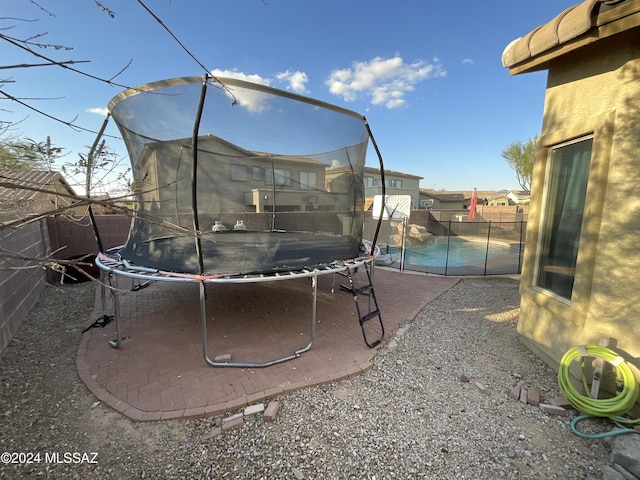 view of yard featuring a fenced in pool and a trampoline