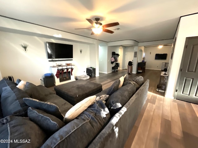 living room featuring hardwood / wood-style floors and ceiling fan