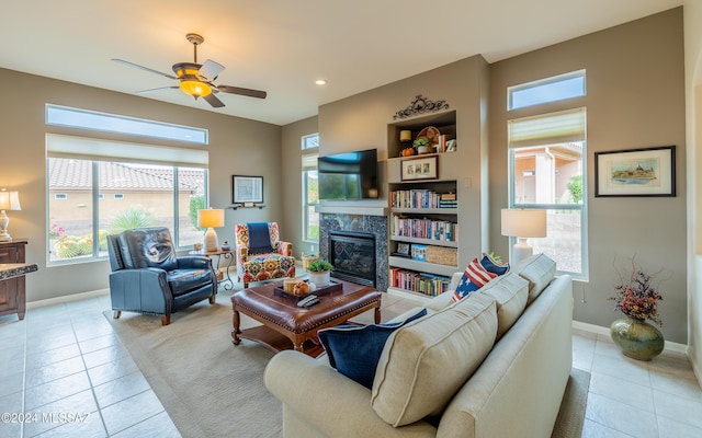 living room with ceiling fan, light tile patterned floors, and a high end fireplace