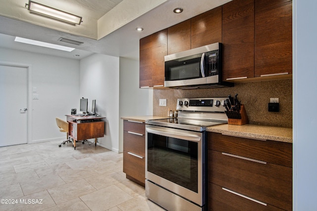 kitchen with tasteful backsplash, appliances with stainless steel finishes, and light tile patterned floors