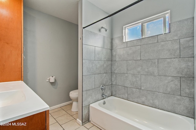 full bathroom with tile patterned flooring, vanity, tiled shower / bath, and toilet